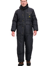 Load image into Gallery viewer, A man wearing a heavy black quilted winter jumpsuit with brass snap buttons and a small yellow logo patch on the chest, standing against a plain white background.